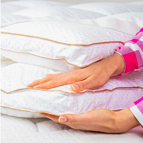 Mãos femininas mostrando a altura de 10cm do Pillow Top Magnum que promove maior conforto para noites de sono perfeitas