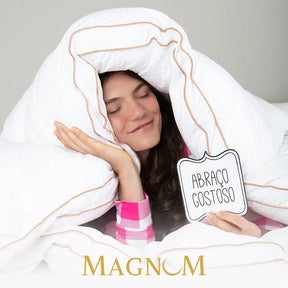 Mulher relaxando em sua cama envolvida pelo nosso pillow top magnum Pluma AirFiber IWS demonstrando seu conforto e maciez que lembra um abraço gostoso, sua  tecnologia de preenchimento gomo a gomo assegura um ajuste perfeito, independentemente do seu tipo de colchão proporcionando uma noite de sono digna de um hotel 5 estrelas.